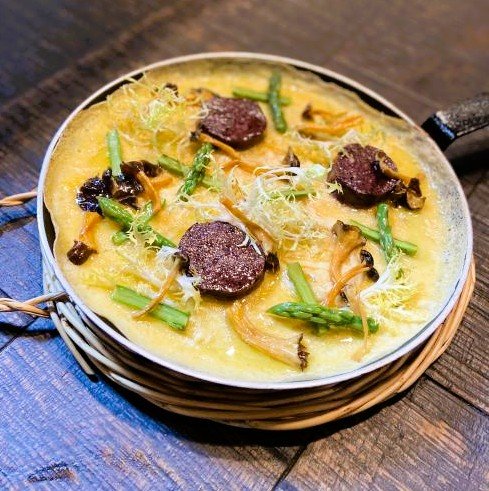 Trompeta groga, camagroc, rossinyol ataronjat, “angula” de muntanya... Aquest bolet de vius colors que floreix entrada la tardor és un dels més reconeixibles de la temporada, i cada vegada guanya més terreny en cuines particulars i professionals. "És una de les que més triomfa. A tots els mercats arriba a una dimensió enorme", explica Llorenç Petràs, que ha venut bolets a la Boqueria de Barcelona durant més de 50 anys. Aquest fong de mida petita amb barret marró, peu ataronjat, prim i elàstic creix en boscos de pins formant grans colònies i és dels pocs que resisteix a les gelades, per això es pot recol·lectar també a l'hivern. Amb aroma agradable i sabor dolç, un dels grans avantatges del camagroc (de nom científic Cantharellus lutescens) és que resulta fàcil de cuinar i no requereix coccions llargues, explica Iván Cruz, xef de Tramendu Restaurant, a Barcelona. "És aromàtic i versàtil. Queda molt bé en guisats, però també en cremes, sopes i truites". Quan estan en temporada, els usem per elaborar una crema amb trompetes de la mort que banya un caneló. "Deixem que els bolets deixin anar tota l'aigua, i els triturem amb ajuda d'un robot de cuina per aconseguir una textura fina". A la vermuteria amb el mateix nom, que és a pocs metres del restaurant, serveixen també unes manetes de porc que guisen amb aquests bolets. "També queden riquíssimes fregides amb un ou o en un arròs melós". A Gaig Barcelona, ​​les trompetes grogues són les encarregades de donar color i sabor a una truita oberta, una recepta que es pot preparar fàcilment a casa batent els ous, tirant-los a la paella i cobrint-los amb els camagrocs prèviament saltats, que es fixaran quan l'ou comenci a quallar. El xef executiu del restaurant de Carles Gaig, Josep Armenteros, també coincideix que a aquests bolets, com a les trompetes de la mort (que són de la mateixa família), els gaudim molt bé als guisats. "Podem utilitzar-les en un fricandó, substituint-les pels moixernons, o en un guisat de mar i muntanya". Al País Basc, la trompeta groga rep el nom d'angula de muntanya per la seva semblança en grandària amb l'aleví de l'anguila. També perquè es poden preparar igual, saltant-les amb un rajolí d'oli, all, bitxo i julivert. "Aquí tenim molta tradició boletaire”. Les trompetes grogues les fem servir en truites com la de bacallà. Se salten els bolets frescos, es barregen amb l'ou i el peix, i llest", afirma el xef bilbaí Álvaro Garrido, de la Mina, al qual també li agrada afegir les angules de muntanya els vins". I proposa una recepta: sofregir all i ceba morada en una mica oli, amb romaní, cansalada adobada, pebrot xoricer, tomàquet i brou de pollastre o de peix. Al final, s'hi afegeixen les senderoles "i tens una sopa de bolets increïble". 