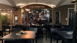 L’Alternativa és un bar de tapes i restaurant situat a la plaça Guillemó, (Plaça de les Arcades) al centre d’Andorra la Vella, pensat per fer un vermut, picar alguna cosa o sopar tranquil·lament amb bona música i ambient informal. Ha esdevingut una alternativa gastronòmica molt popular tant per a gent del país com per a visitants que busquen tapes i vins prèmium a preus populars en un entorn informal però cuidat.​ Entre els seus serveis principals destaquen: Bar de tapes amb una àmplia selecció de tapes, carns prèmium, embotits, formatges, croquetes i plats per compartir, on el pernil ibèric i altres productes espanyols tenen un gran protagonisme.​ Gran Carta de vins amb més de 140 referències, cerveses variades, amb especial atenció als vins espanyols i a la cervesa ben tirada, ideal per a l’“afterwork” o per a fer el “tardeo” amb amics.​ Menús i propostes de migdia o vespre amb plats casolans i tapes calentes, pensats per menjar bé sense haver de fer un àpat massa formal.​ Carns prèmium com el secreto o A més, L’Alternativa també funciona com a espai de trobada i d’oci: organitza propostes especials, horaris de “happy hour” amb oferta de begudes i tapes, i sovint és recomanat com un lloc amb molt bon ambient per començar o acabar la nit al centre d’Andorra la Vella.